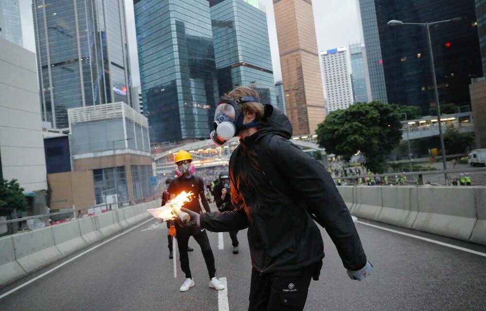 WAR! Hong Kong on lockdown after student, 18, SHOT in chest by cop and another officer threatens to throw Molotov cocktails at protesters as streets turned into battlefield